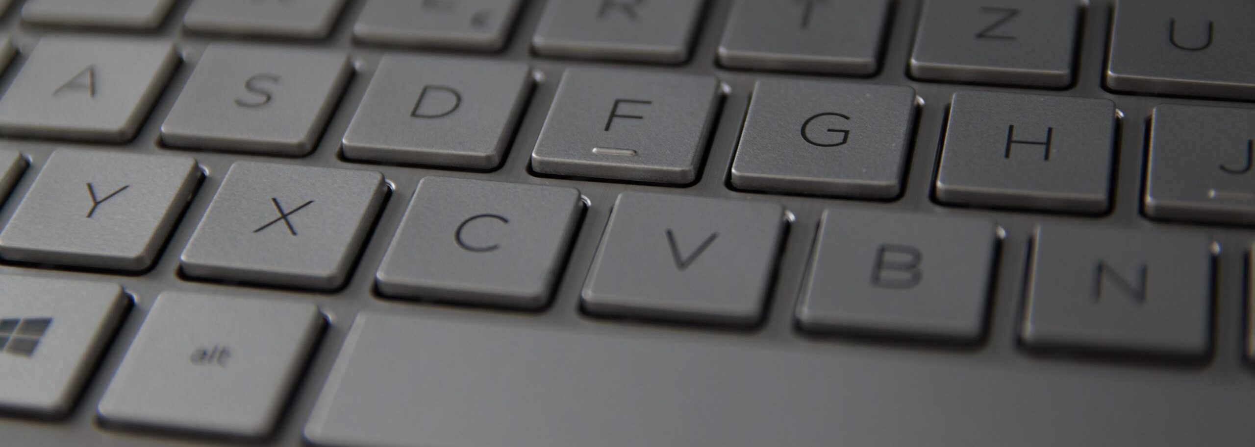 Detailed close-up of a sleek metallic German keyboard with QWERTZ layout.